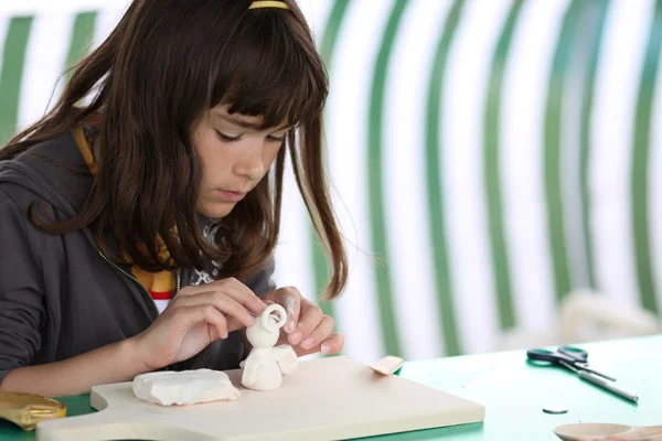 Girl making clay angel — Stock Photo, Image