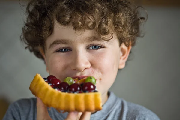 Junge isst fruchtigen Kuchen — Stockfoto