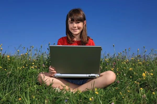 Fille avec ordinateur portable sur prairie verte — Photo