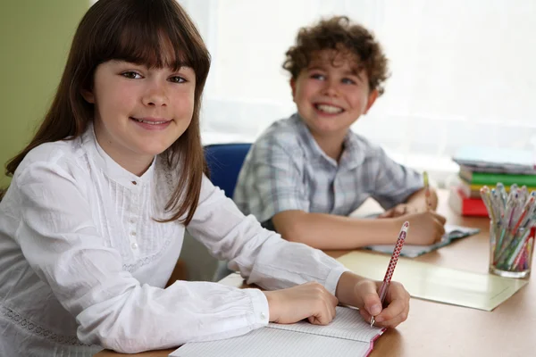 Chica y niño haciendo la tarea — Foto de Stock