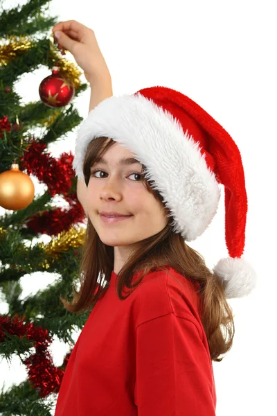 Fiatal lány santa díszítő karácsonyfa — Stock Fotó