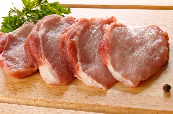 Lices of fresh pork meat with parsley — Stock Photo, Image