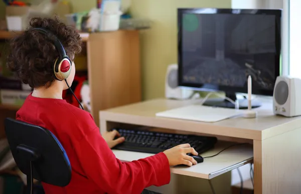 Jonge jongen met computer thuis — Stockfoto