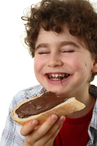 Poika syö leipää pähkinävoin kanssa. — kuvapankkivalokuva
