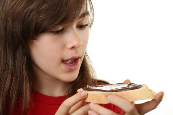 Tjej äter bröd med mutter smör — Stockfoto