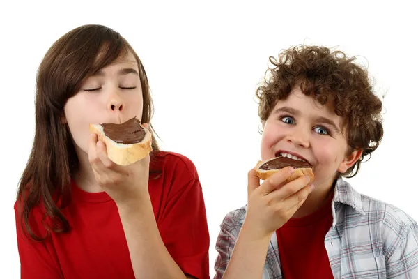 Kids eating bread with nut butter — Stock Photo, Image