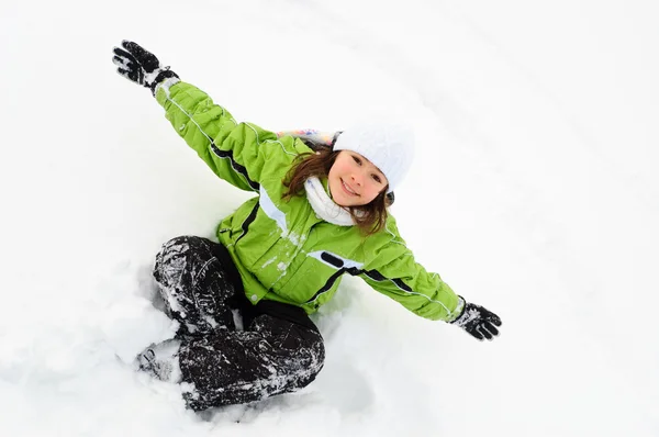 Chica jugando en el campo cubierto de nieve — Foto de Stock