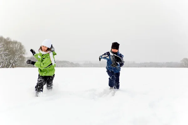 Niños corriendo en el campo cubierto de nieve — Foto de Stock