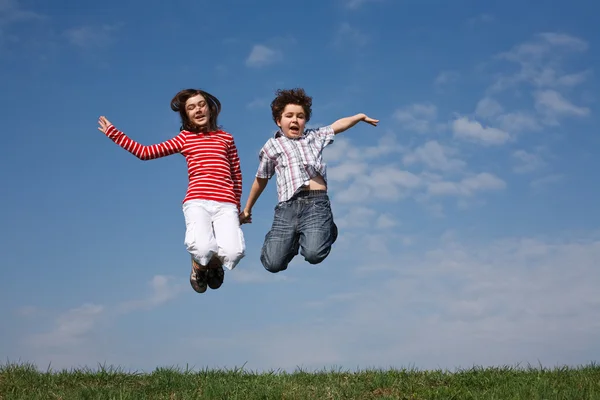 Girl and boy jumping outdoor — Stock Photo, Image