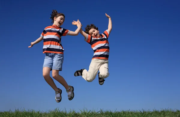 Mädchen und Junge springen im Freien — Stockfoto