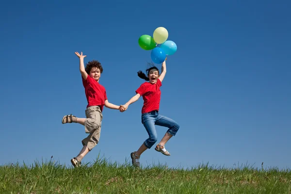 Niños sosteniendo globos, jugando al aire libre —  Fotos de Stock