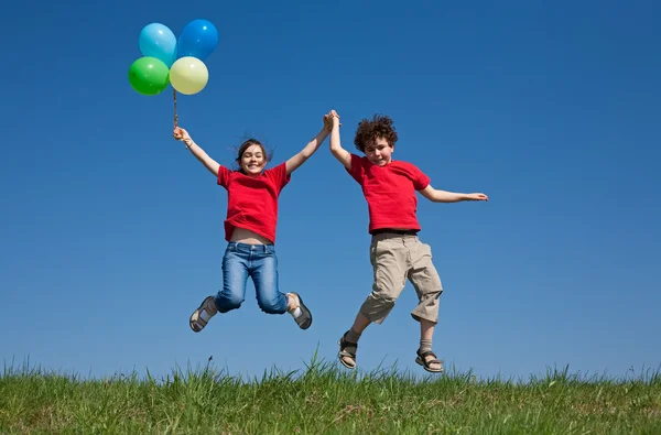 Niños sosteniendo globos, jugando al aire libre —  Fotos de Stock