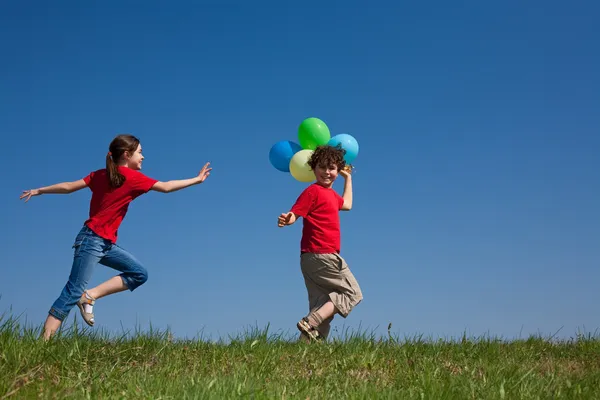 Niños sosteniendo globos — Foto de Stock