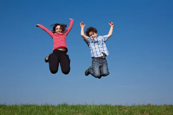 Girl and boy jumping outdoor Stock Photo