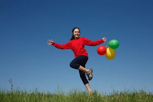 Ragazza che salta con palloncini — Foto Stock