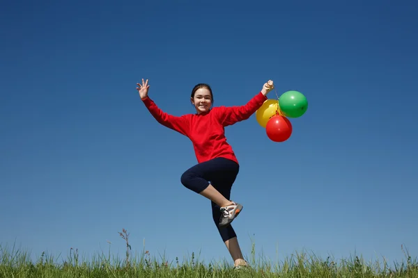 Ragazza che salta con palloncini — Foto Stock