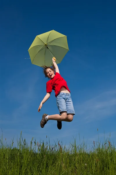 Menina pulando, voando com guarda-chuva verde — Fotografia de Stock