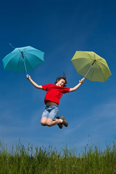 Dívka, která skočila s deštníkem proti modré obloze — Stock fotografie