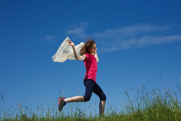 Menina correndo contra o céu azul — Fotografia de Stock