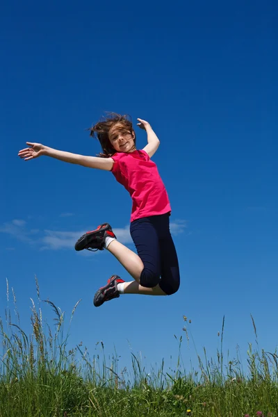 Девушка прыгает и бежит по зеленому лугу — стоковое фото