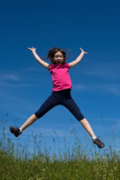 Meisje lopen, springen buitenshuis — Stockfoto