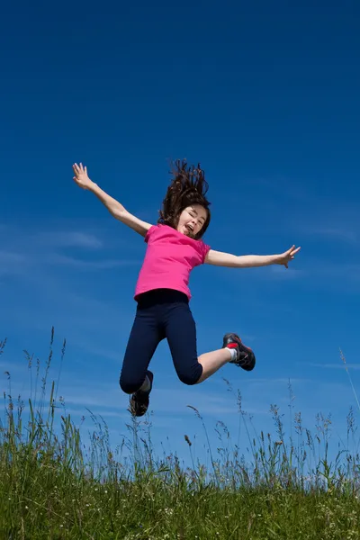 Meisje lopen, springen buitenshuis — Stockfoto