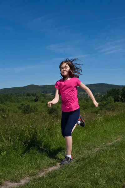 Meisje lopen, springen buitenshuis — Stockfoto