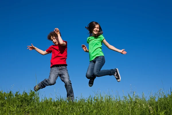 Mädchen und Junge springen im Freien — Stockfoto