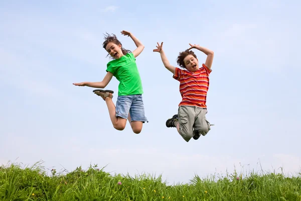 Κορίτσι και αγόρι, jumping, λειτουργίας εξωτερική — Φωτογραφία Αρχείου