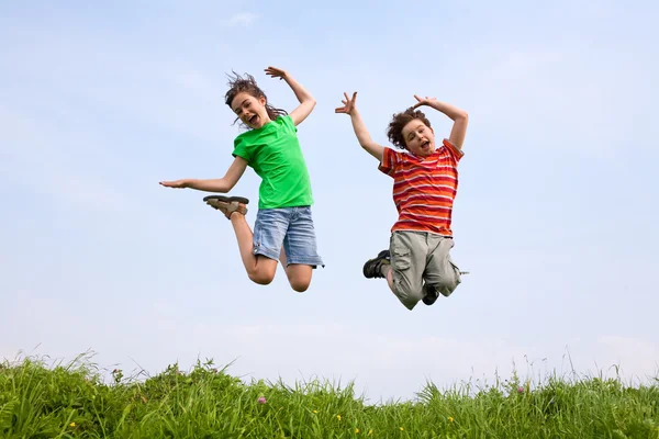 Girl and boy jumping, running outdoor — Stock Photo, Image