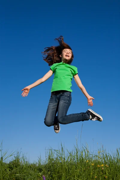 Chica saltando contra el cielo azul — Foto de Stock