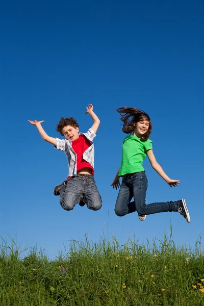 Chica y niño saltando al aire libre — Foto de Stock