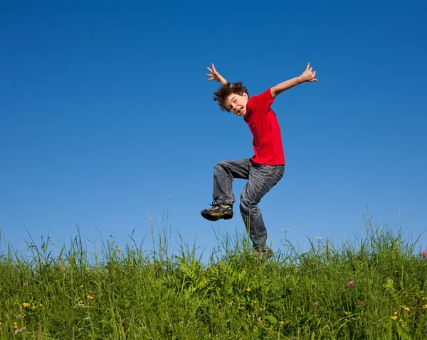 Niño saltando contra el cielo azul — Foto de Stock