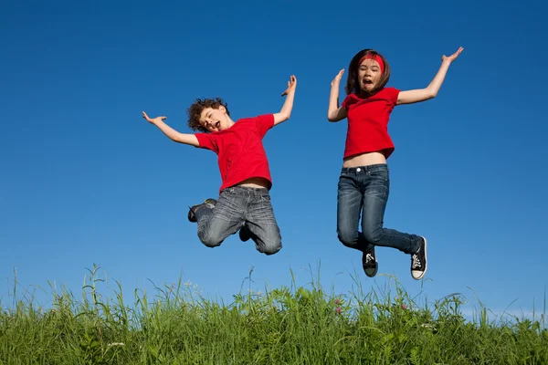 Girl and boy jumping — Stock Photo, Image