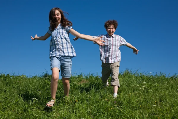 Chica y niño corriendo al aire libre — Foto de Stock