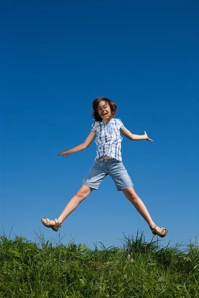 Menina saltando contra o céu azul — Fotografia de Stock