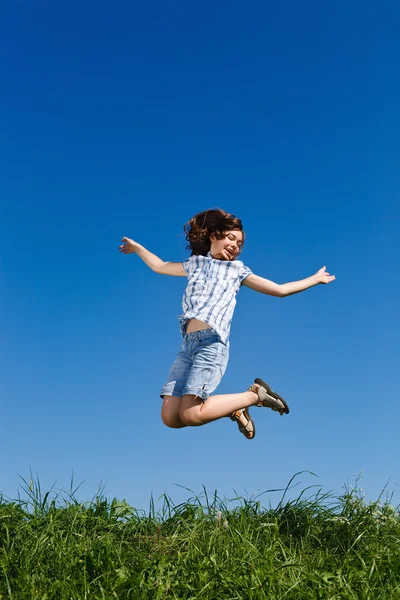 Menina saltando contra o céu azul — Fotografia de Stock