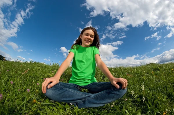 Fille relaxant sur prairie verte — Photo