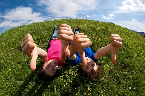 Kids relaxing on green meadow — Stock Photo, Image