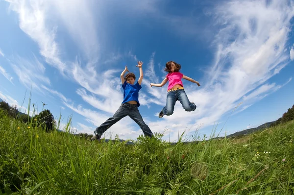 Flicka och pojke hoppning utomhus — Stockfoto