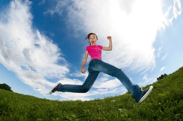 Menina saltando contra o céu azul — Fotografia de Stock