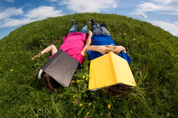 Crianças relaxando no prado verde — Fotografia de Stock