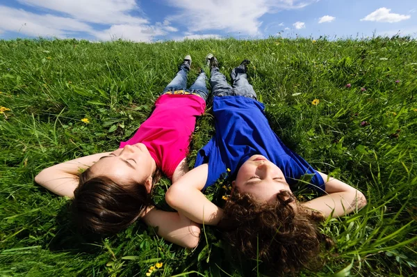 Çocuklar yeşil çayır üzerinde rahatlatıcı — Stok fotoğraf