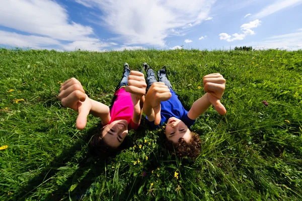 Kids relaxing on green meadow — Stock Photo, Image