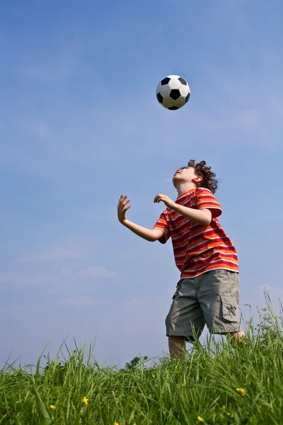 Chlapec hraje fotbal Stock Snímky