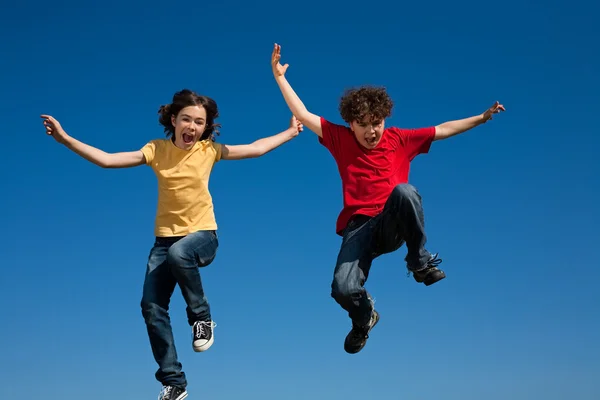 Meisje en jongen buiten springen — Stockfoto