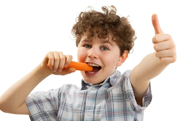 Menino comendo cenouras frescas — Fotografia de Stock