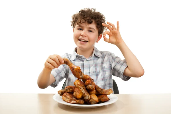 Menino comendo baquetas de frango — Fotografia de Stock