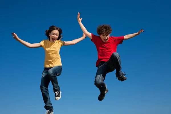 Girl and boy jumping outdoor Stock Photo