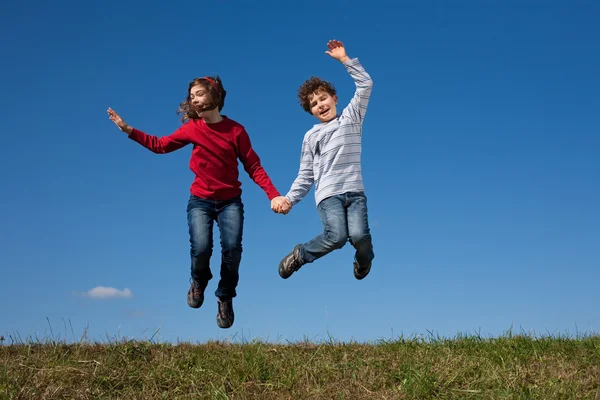 Les enfants sautent contre le ciel bleu — Photo